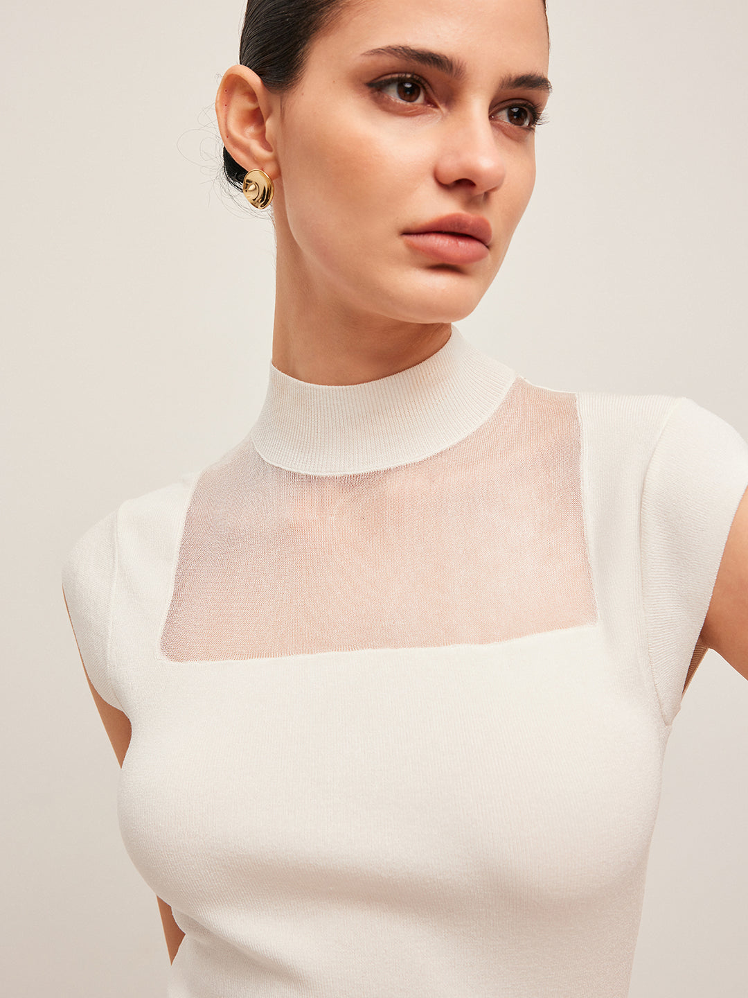 Mouwloos topje met mesh detail en hoge hals
