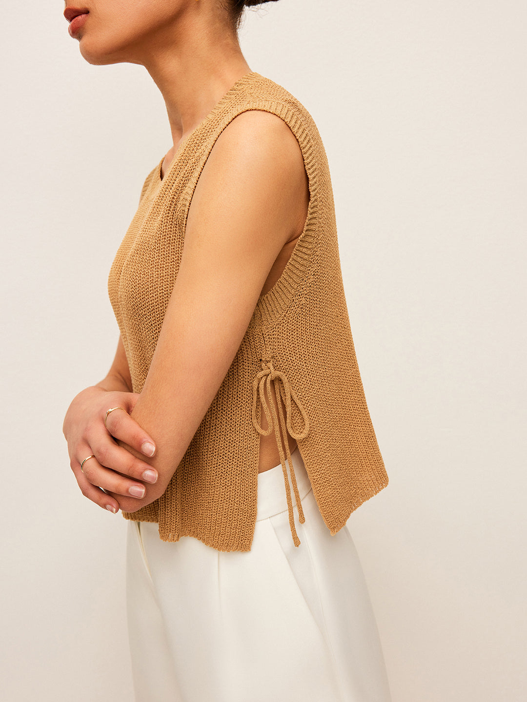 Beige gebreide mouwloze top met vetersluiting aan de zijkant