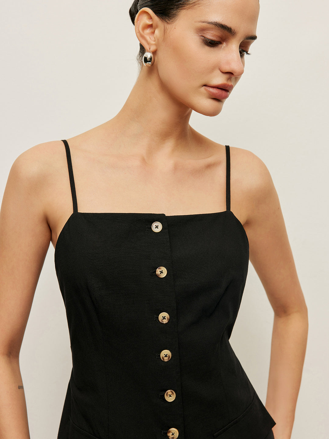 Zwarte tanktop met knopen en zakdetails