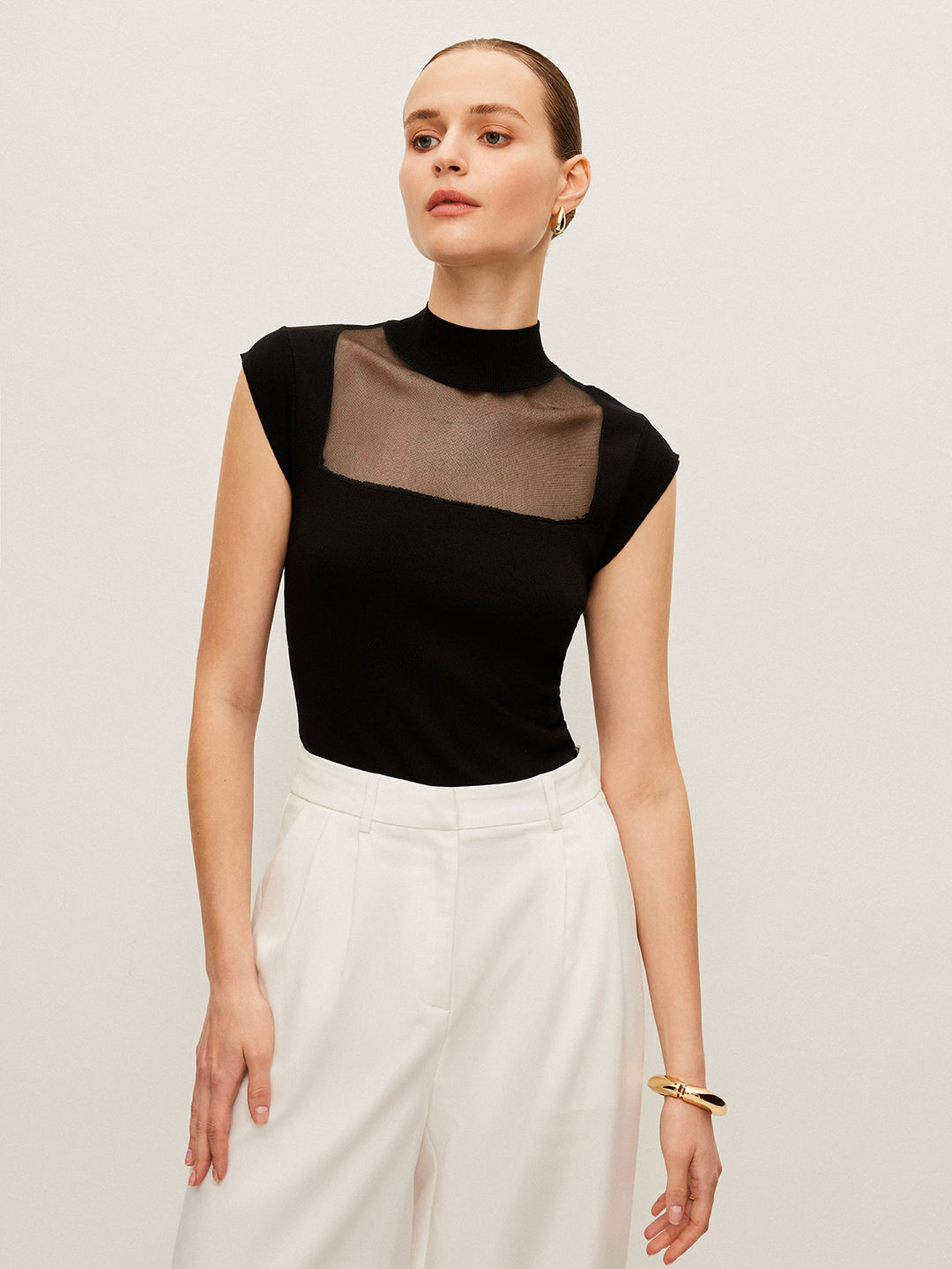 Mouwloos topje met mesh detail en hoge hals