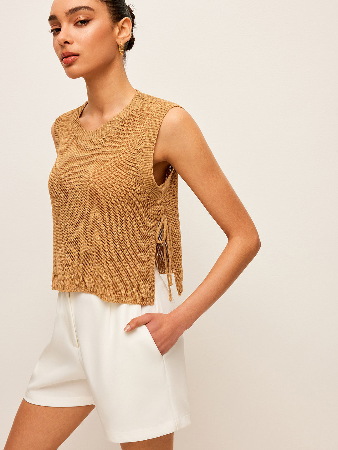 Beige gebreide mouwloze top met vetersluiting aan de zijkant