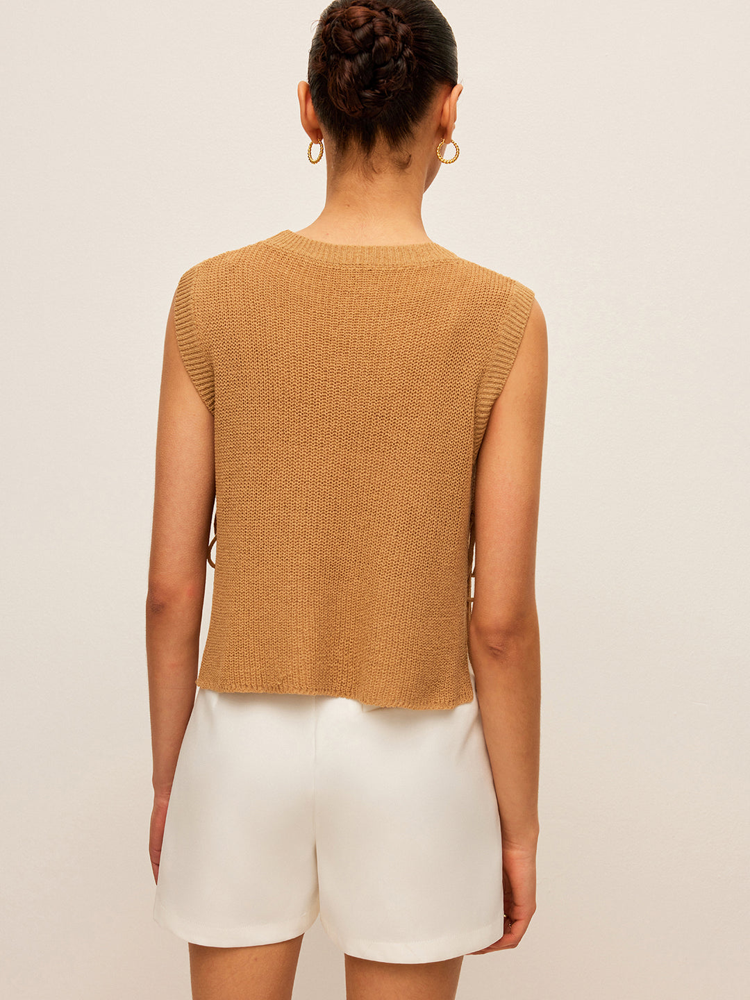 Beige gebreide mouwloze top met vetersluiting aan de zijkant