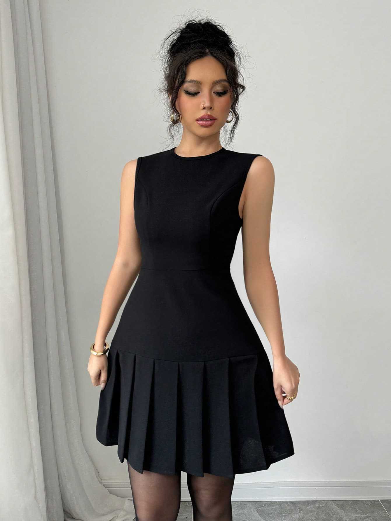 Zwarte mouwloze mini-jurk met geplooide rok